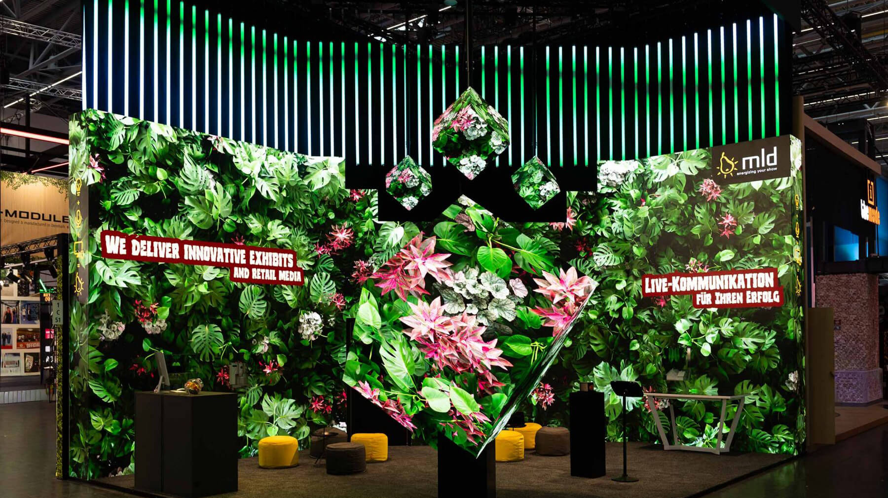 Digitale Vegetation überwuchert die LED-Flächen, grüne Lichtstimmungen tauchen den Stand in eine immersive Regenwald-Atmosphäre. Polychroms Motion Design macht den Raum lebendig.
